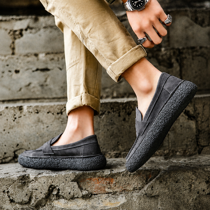 Mocassins Suède Célian gris anthracite, gros plan portés avec pantalon beige sur des marches en pierre